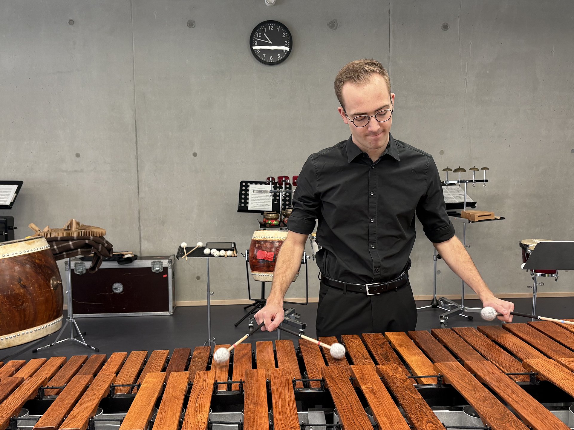 Ein Junger Mann spielt an einer Marimba mit drei Schlägern