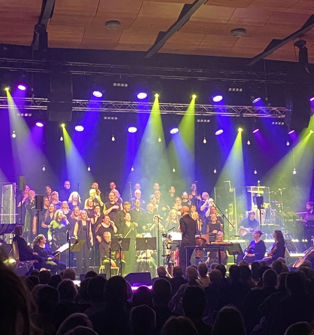 Ein Chor singt auf einer Bühne im Rampenlicht
